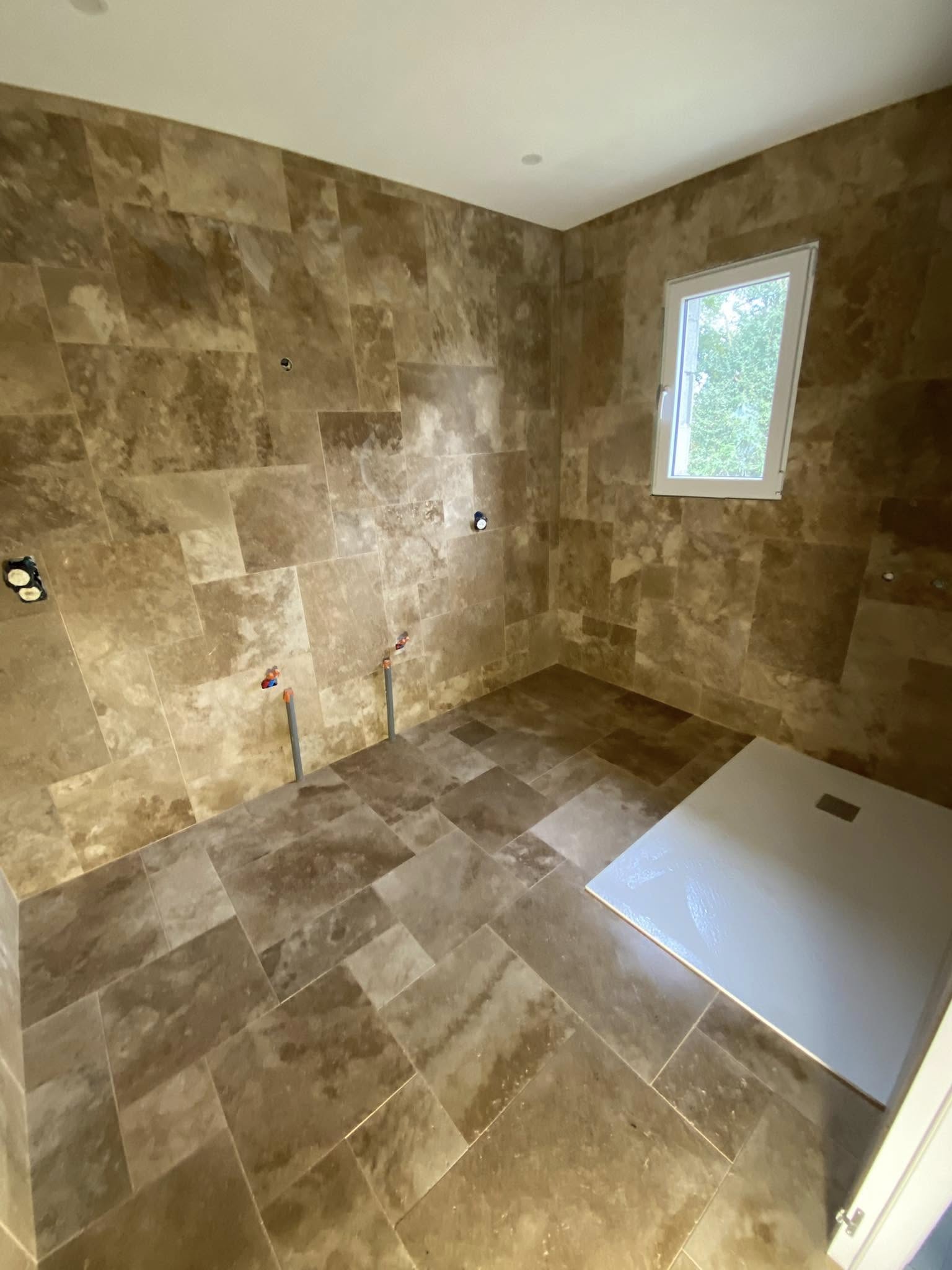 Réalisation d’une salle de bain en travertin multi formats