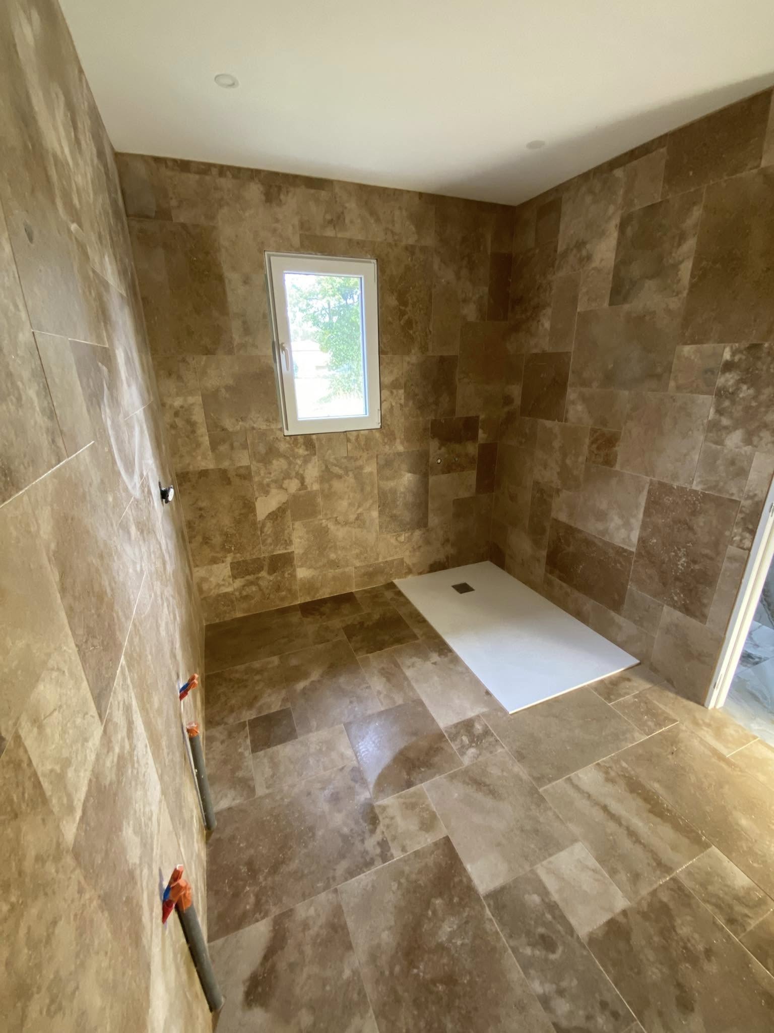 Réalisation d’une salle de bain en travertin multi formats